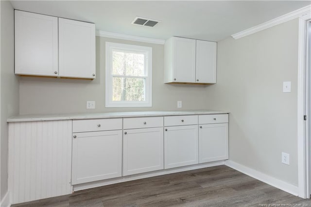 kitchen featuring white cabinetry, crown molding, light countertops, dark wood-style floors, and baseboards