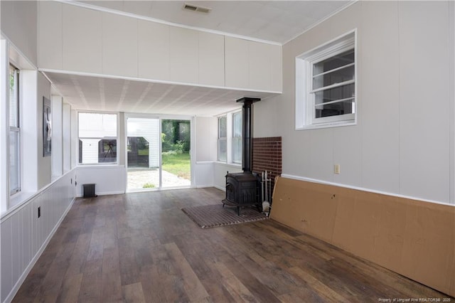 unfurnished living room with a wood stove and wood finished floors