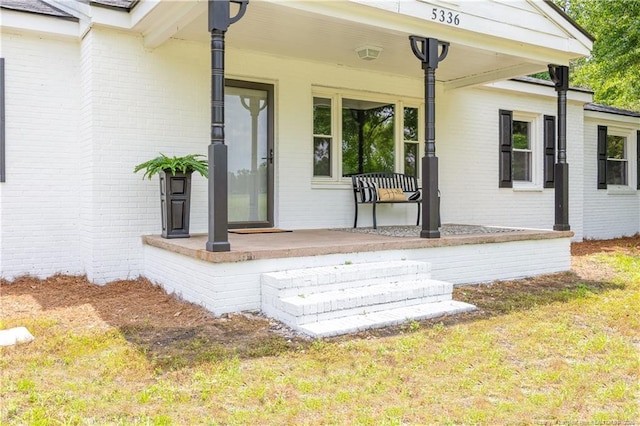 wooden deck featuring a porch and a lawn