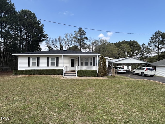 view of front of property featuring a front lawn, a carport, covered porch, and driveway