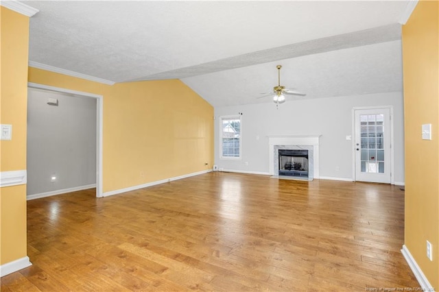 unfurnished living room featuring baseboards, ceiling fan, light wood-type flooring, lofted ceiling, and a premium fireplace