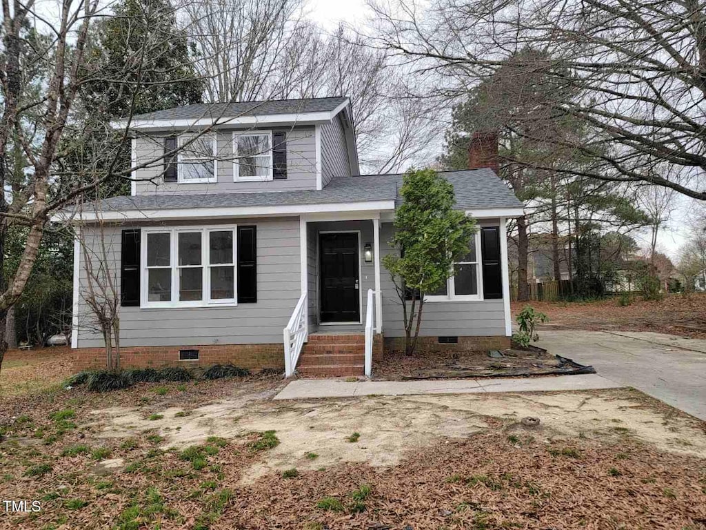 traditional-style home featuring crawl space, roof with shingles, and concrete driveway