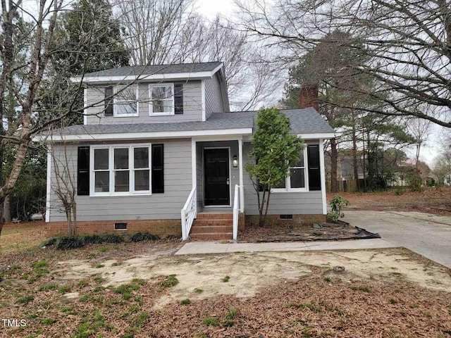 traditional-style home featuring crawl space, roof with shingles, and concrete driveway