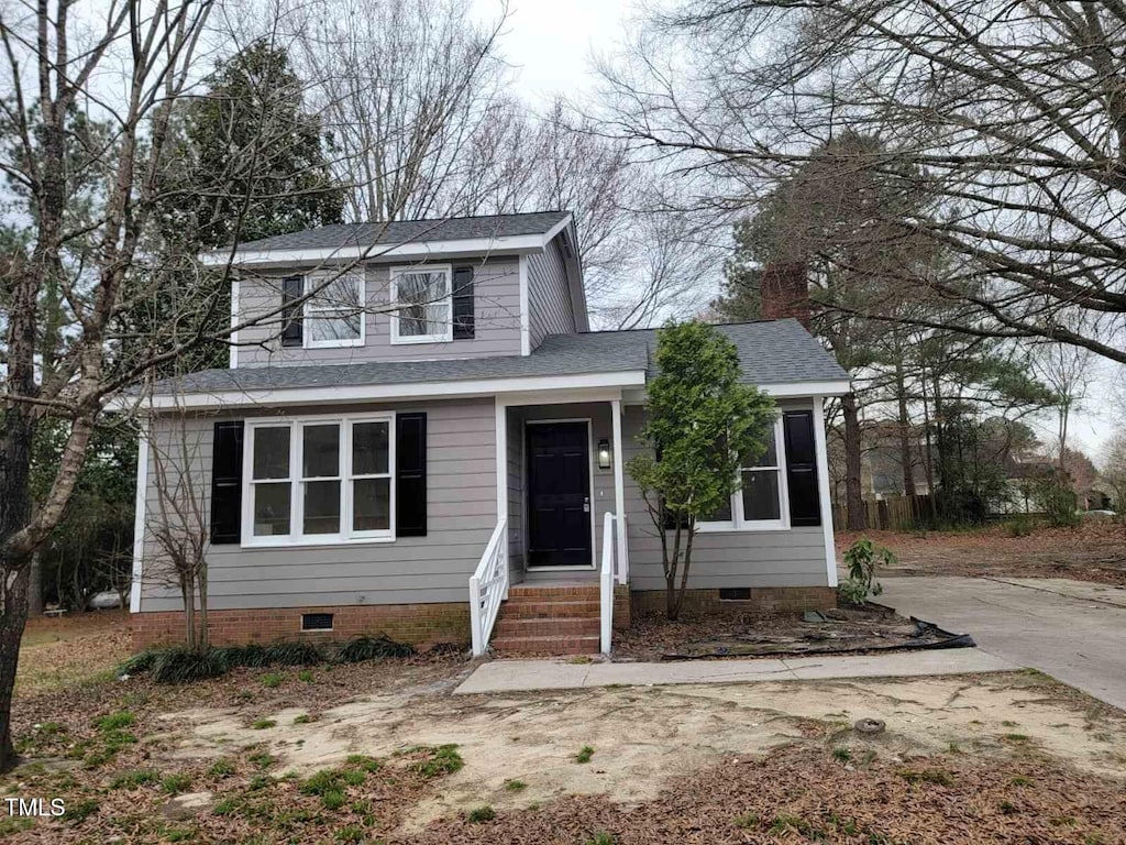 traditional home featuring crawl space, concrete driveway, and roof with shingles