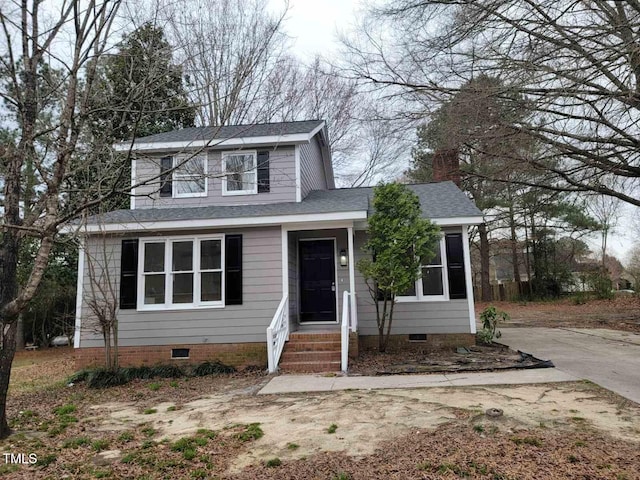 traditional home featuring crawl space, concrete driveway, and roof with shingles