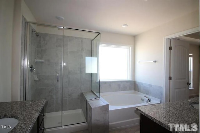 bathroom with vanity, a shower stall, and a garden tub