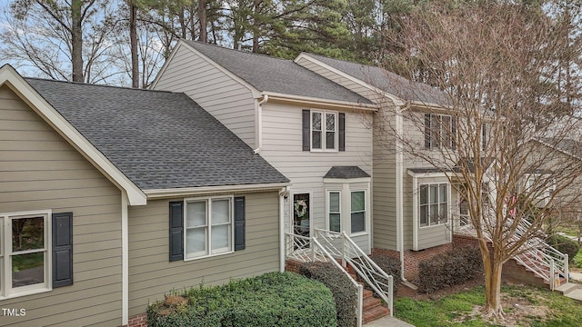 view of front of home featuring stairway and a shingled roof