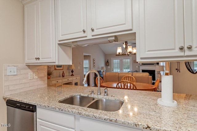 kitchen with dishwasher, decorative backsplash, white cabinetry, and a sink
