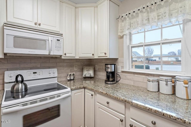 kitchen with decorative backsplash, white appliances, and white cabinetry