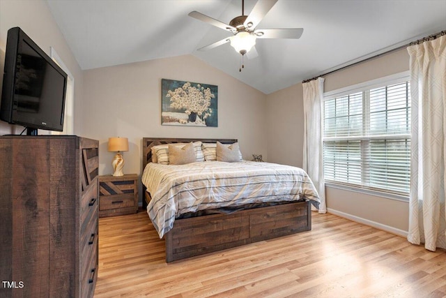 bedroom featuring light wood-type flooring, lofted ceiling, baseboards, and ceiling fan