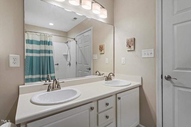 full bathroom with double vanity, a shower with curtain, visible vents, and a sink