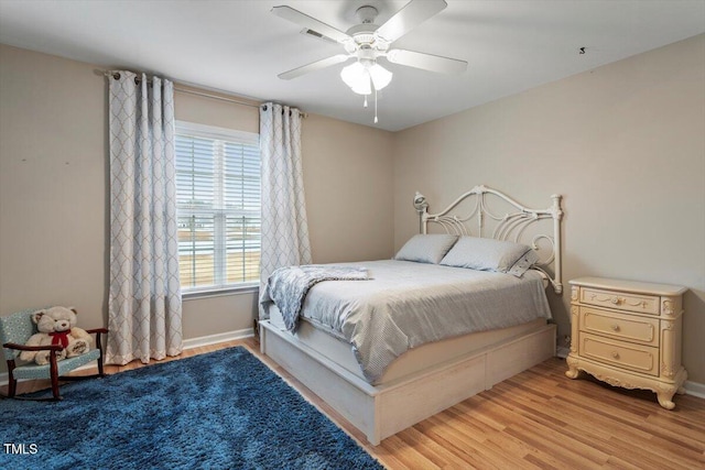 bedroom with ceiling fan, baseboards, and light wood-style floors
