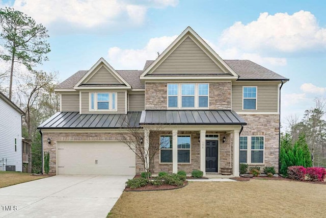 craftsman-style home featuring stone siding, an attached garage, concrete driveway, and a standing seam roof