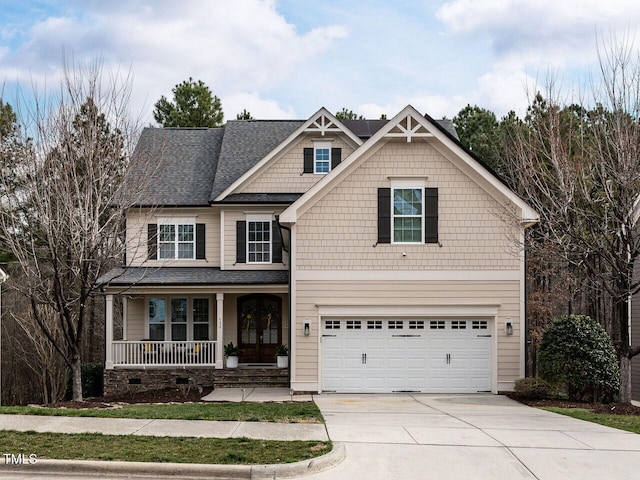 craftsman-style home featuring a garage, covered porch, and concrete driveway