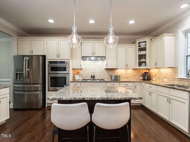 730 Toms Creek Rd, Cary, NC 27519 - kitchen featuring a center island, a sink, crown molding, under cabinet range hood, and appliances with stainless steel finishes