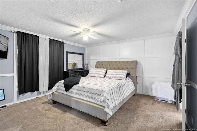 bedroom featuring a decorative wall, ornamental molding, a textured ceiling, and carpet floors