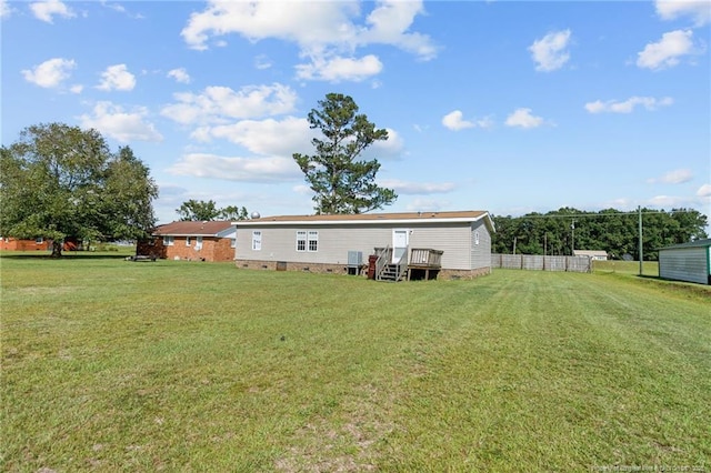 rear view of house with crawl space, a yard, and fence