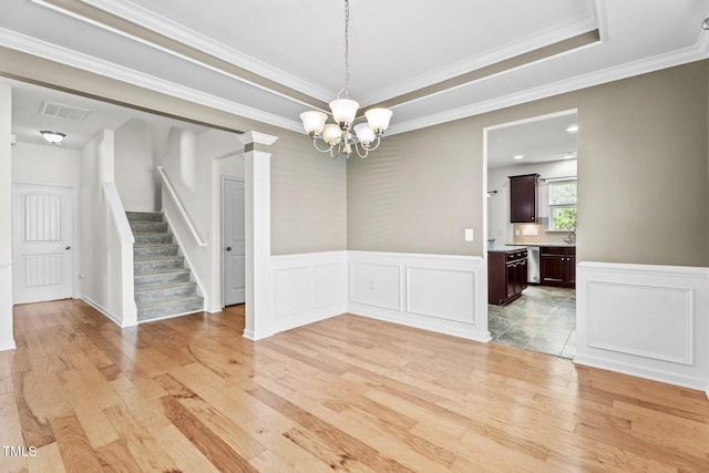 69 Florence Dr, Clayton, NC 27527 - unfurnished dining area with visible vents, wainscoting, an inviting chandelier, and light wood-style floors