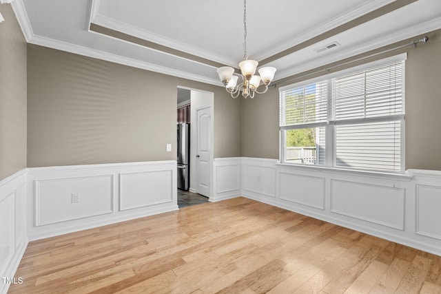 69 Florence Dr, Clayton, NC 27527 - unfurnished room with light wood finished floors, an inviting chandelier, a tray ceiling, and visible vents