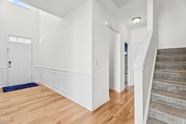 69 Florence Dr, Clayton, NC 27527 - foyer entrance featuring stairway, visible vents, a wainscoted wall, and light wood-style flooring