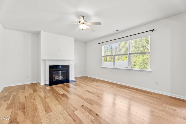 69 Florence Dr, Clayton, NC 27527 - unfurnished living room with visible vents, baseboards, ceiling fan, light wood-style floors, and a glass covered fireplace