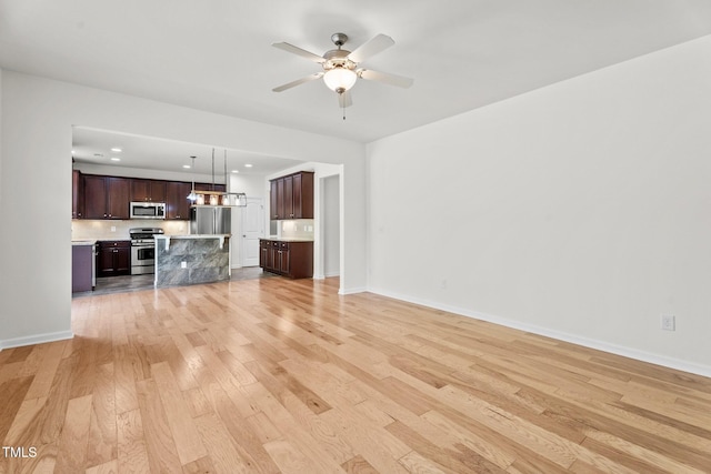 69 Florence Dr, Clayton, NC 27527 - unfurnished living room with light wood-type flooring, baseboards, and a ceiling fan