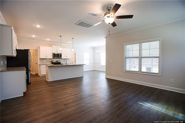 kitchen featuring backsplash, stainless steel appliances, ceiling fan with notable chandelier, and ornamental molding
