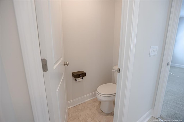 bathroom with toilet and baseboards