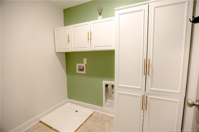 laundry area with baseboards, washer hookup, and cabinet space
