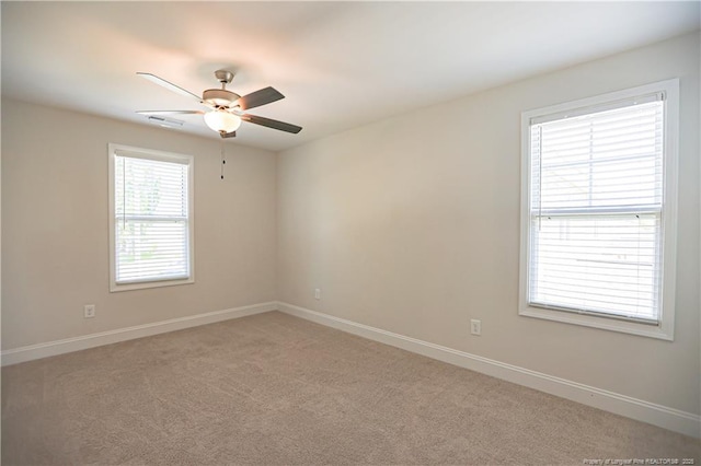 empty room with light carpet, baseboards, and a ceiling fan