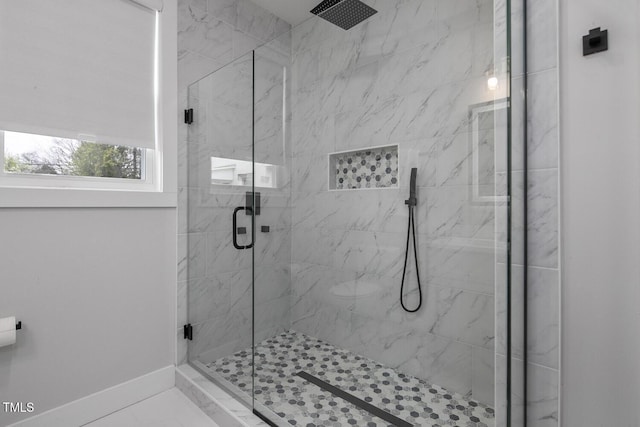 bathroom featuring a marble finish shower and baseboards