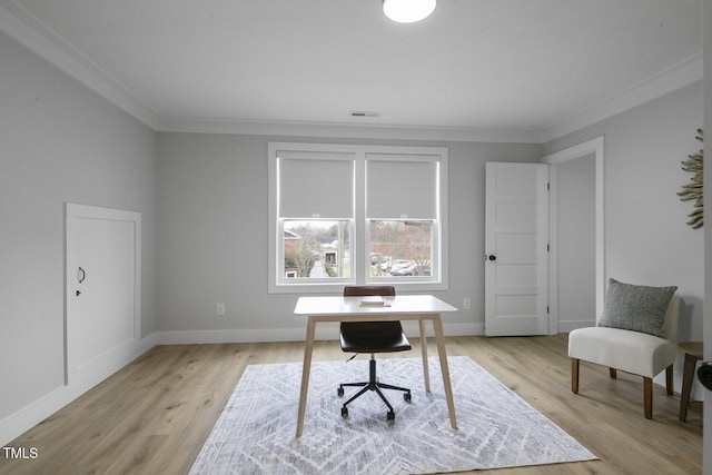 office featuring light wood-type flooring, baseboards, visible vents, and ornamental molding