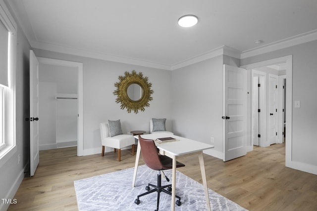 office space featuring baseboards, crown molding, and light wood finished floors