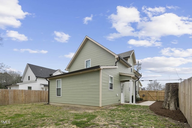 rear view of house with a lawn and a fenced backyard