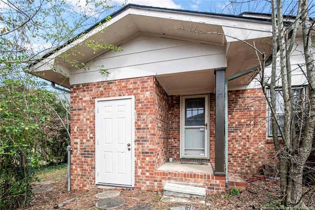 view of exterior entry with brick siding