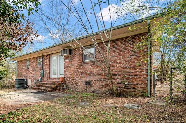 back of property featuring brick siding, cooling unit, and entry steps