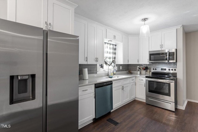 1803 Saint Paul Ave, Fayetteville, NC 28304 - kitchen with a sink, tasteful backsplash, appliances with stainless steel finishes, light countertops, and dark wood-style flooring