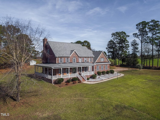 view of front of house featuring a chimney, a porch, and a front lawn