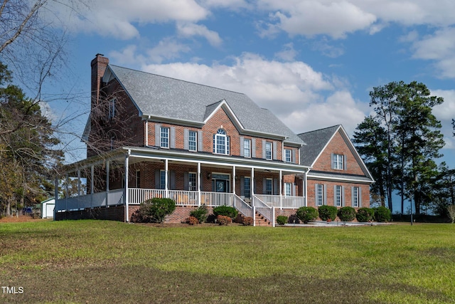 view of front of home featuring a chimney, brick siding, a porch, and a front lawn