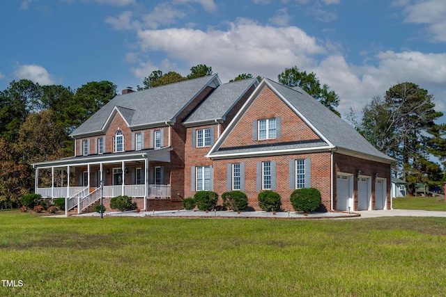 view of front of home featuring brick siding, a porch, a front yard, a chimney, and a garage