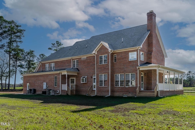 rear view of property with a lawn, brick siding, and a chimney