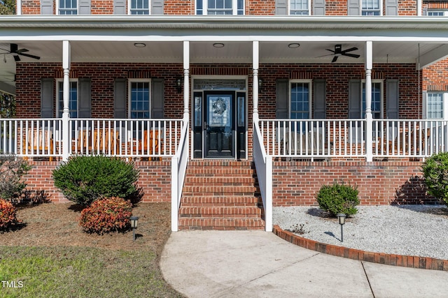 property entrance featuring a porch, brick siding, and ceiling fan