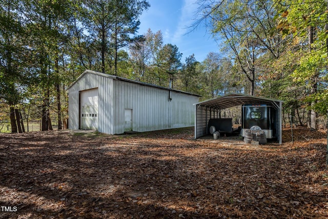 view of outdoor structure with a carport and an outbuilding