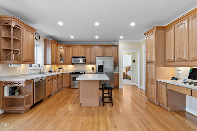 kitchen with open shelves, a sink, appliances with stainless steel finishes, a kitchen bar, and light wood-type flooring