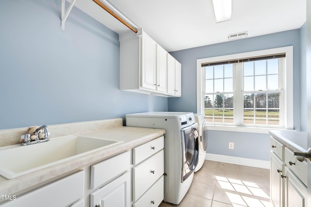 clothes washing area with visible vents, light tile patterned flooring, cabinet space, a sink, and washing machine and dryer