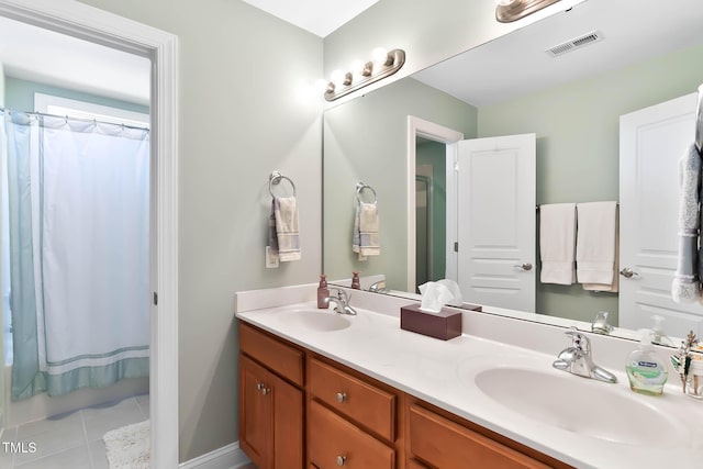 bathroom featuring tile patterned flooring, double vanity, visible vents, and a sink