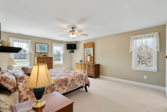 bedroom featuring light carpet, ceiling fan, and baseboards