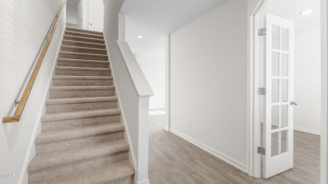 stairs with recessed lighting, wood finished floors, and baseboards