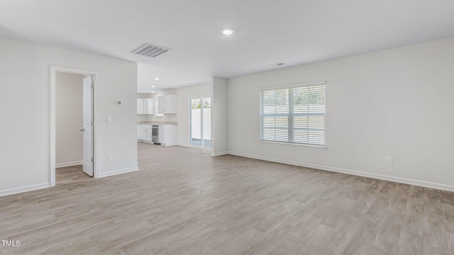 unfurnished living room featuring recessed lighting, light wood-style floors, visible vents, and baseboards