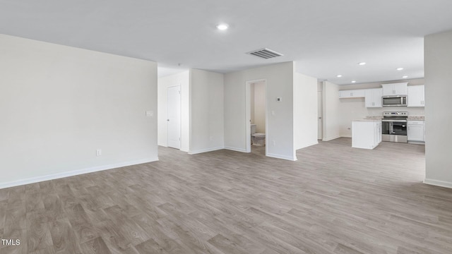 unfurnished living room featuring recessed lighting, light wood-type flooring, baseboards, and visible vents